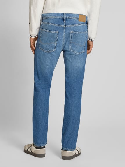 Männermodel trägt Regular Fit Jeans im Used-Look Modell 'CLARK' von Jack & Jones aus puur katoen met steekzakken, blauwe denim, ganzkörperansicht rückansicht.