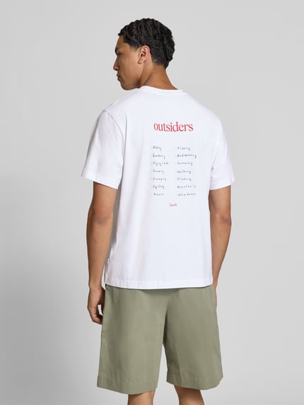 Männermodel trägt Regular Fit T-Shirt mit Statement-Print von Forét aus bawełna, okrągły dekolt, krótki rękaw, długość tyłu 67 cm, Ganzkörperansicht Rückansicht.