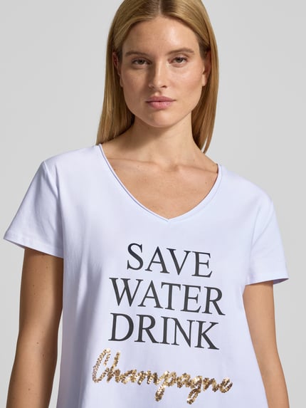 Modelka prezentuje T-shirt mit Statement-Print od miss goodlife, mieszanka bawełny i elastanu, luźny krój, dekolt w serek, nadruk z napisem, długość tyłu w rozmiarze S: 66 cm, zbliżenie na górną część ciała