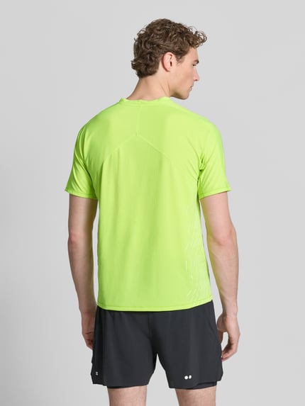 Männermodel trägt Funktionsshirt mit Logo Modell 'SENSE AERO' von Salomon in Neongelb, glatte Struktur, Regular Fit, Rückansicht Ganzkörperansicht.