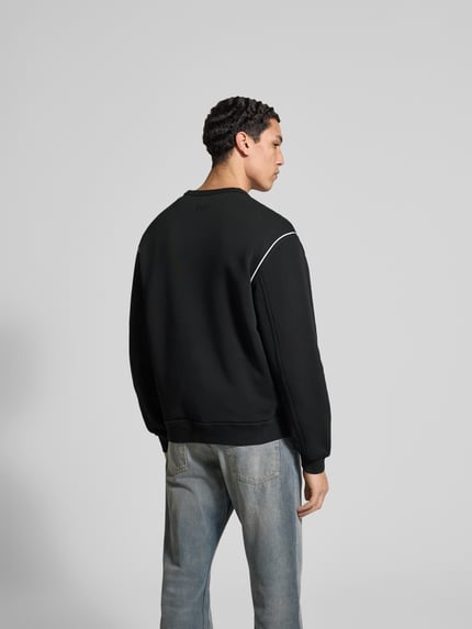 Männermodel trägt Sweatshirt aus reiner Baumwolle von Kenzo in Schwarz mit Label-Detail, lockerer Passform, elastischen Abschlüssen, Rückenlänge bei Größe M 65 cm, Ganzkörperansicht Rückansicht.
