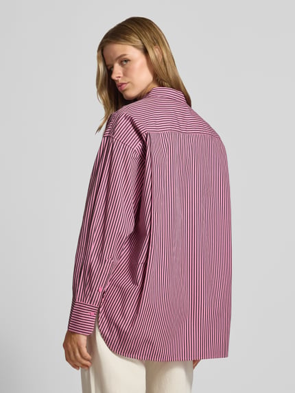 Frauenmodel trägt Relaxed Fit Hemdbluse aus reiner Baumwolle Modell 'JAMIE' von JJXX, gestreift in Rot und Weiß, fließende Struktur, Ganzkörperansicht Rückansicht.