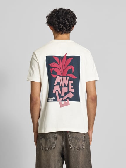 Männermodel trägt Relaxed Fit Oversized Shirt aus reiner Baumwolle von Marc O'Polo Denim, weiß, bunte Print-Applikation, Ganzkörperansicht Rückansicht.