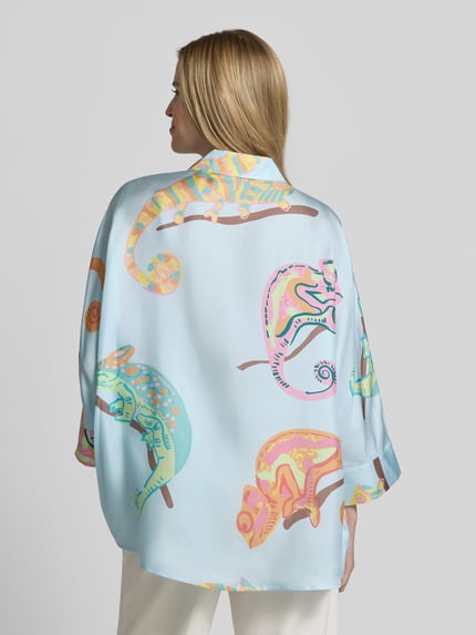 Männermodel trägt Bluse mit Hemdblusenkragen und 3/4-Arm von HERZENS, jasnobłękitny kolor, nadruk kolorowych kameleonów, prosty krój, z zakrytym zapięciem, widok całej sylwetki od tyłu, długość pleców w rozmiarze 36: 20 cm, długość rękawa w rozmiarze 36: 48 cm.