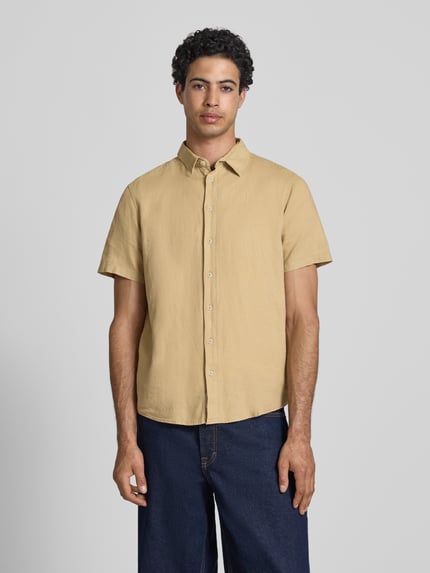 Männermodel trägt Slim Fit Leinenhemd mit Viskose-Anteil Modell 'Bobby' von Blend, Kentkragen, kurzärmelig, beige, Ganzkörperansicht von vorne.
