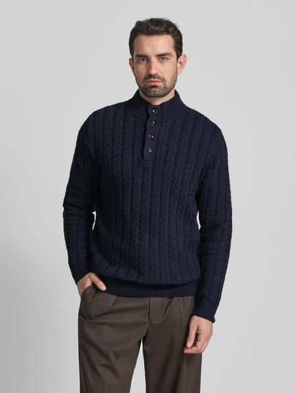 Männermodel trägt Strickpullover mit gerippten Abschlüssen von Fynch-Hatton, dunkelblau, Baumwoll-Woll-Mix, Regular-Fit, Stehkragen, Knopfleiste, Ganzkörperansicht von vorne.