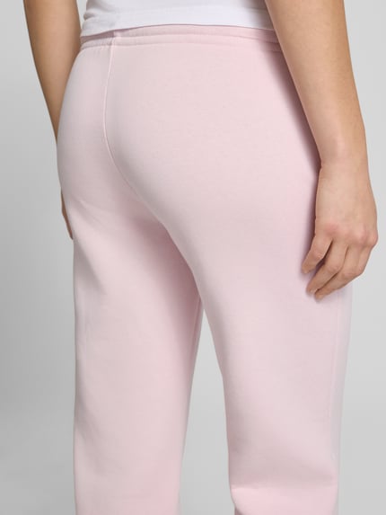 Frauenmodel trägt Sweatpants mit elastischem Bund Modell 'Iconic' von Gina Tricot, rosa Farbton, Baumwoll-Mix, Relaxed-Fit, Detailaufnahme Rückansicht. Damen Sweatpants, Innenbeinlänge bei Größe S: 80 cm.