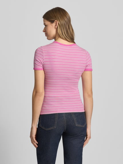 Vrouwenmodel draagt t-shirt met roze en witte strepen, mix van katoen en elastaan, nauwsluitend model 'FRANKIE' van JJXX, ruglengte bij maat S 53 cm, ronde hals, dames t-shirt, rugaanzicht.