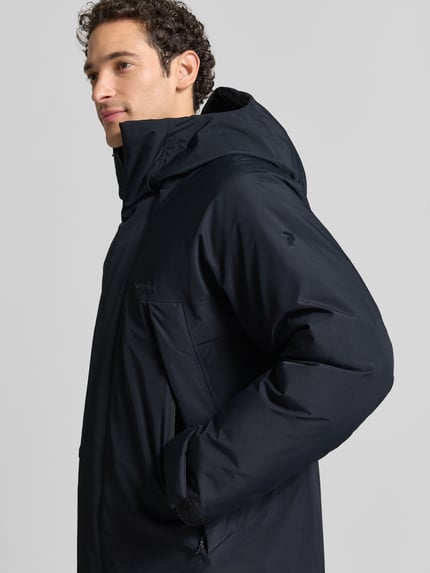 Męski model nosi parka Regular Fit Parka mit Futter aus Alcantara Modell 'Treeline HIPE' od Peak Performance, kolor ciemnogranatowy, podszewka z alcantary, zakryty zamek błyskawiczny, rozmiar M: długość tyłu 102 cm, szerokość ramion 52 cm, szerokość w rozmiarze M 62 cm, długość rękawów 60 cm, z przodu, zbliżenie na górną część ciała.