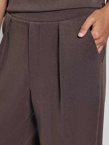 Frauenmodel trägt Sweatpants aus Modal-Mix mit Bundfalten von Rich & Royal in Braun mit Gesäßtaschen und Barrel Fit, Nahaufnahme Oberkörper.