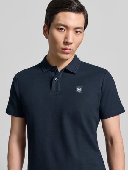Männermodel trägt Regular Fit Poloshirt mit Label-Detail und Knopfleiste von Lerros, Reine Baumwolle, marineblau, Nahaufnahme Oberkörper.