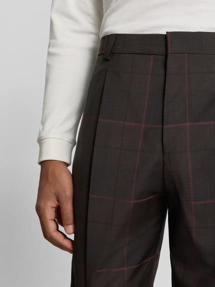 Męskamodel nosi Slim Fit Anzughose aus reiner Schurwolle Modell 'Gatur' von HUGO, ciemnobrązowa z bordową kratą, zbliżenie na górną część, Herren Anzughose von HUGO