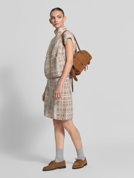 Frauenmodel trägt Knielanger Rock aus reiner Wolle von Christian Berg Woman, beige mit Karomuster, A-Linie, Reißverschluss, Bundweite 39 cm, Gesamtlänge 54 cm, Ganzkörperansicht von vorne.