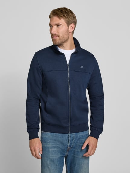 Männermodel trägt Regular Fit Sweatjacke aus Baumwoll-Mix von s.Oliver RED LABEL in Dunkelblau, Ganzkörperansicht von vorne.