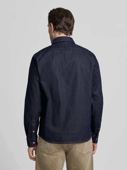 Männermodel trägt Oversized Hemdjacke aus Baumwoll-Mix Modell 'LIAM' von BOSS in Unifarben, Denim-Optik, Ganzkörperansicht Rückansicht.