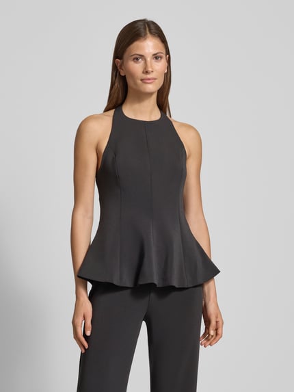 Frauenmodel trägt Neckholder-Blusentop Modell 'XCAMILO' von Mango, schwarzer Material-Mix mit Stretch-Anteil, taillierter Schnitt, Ganzkörperansicht von vorne.