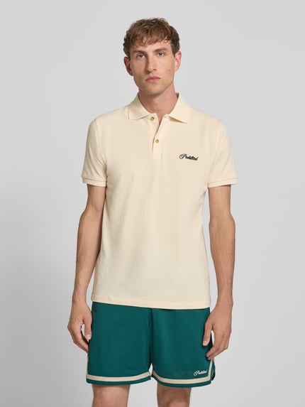 Męski model nosi koszulkę polo z bawełny krój slim fit PROHIBITED, model 'Hampton', wyhaftowane logo, listwa guzikowa, długość tyłu 64 cm w rozmiarze M, widok całej sylwetki z przodu