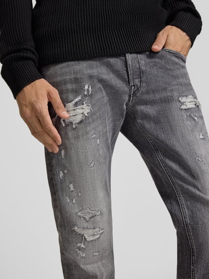 Männermodel trägt Straight Fit Jeans im Used-Look Modell 'Grover' von Replay, Baumwoll-Mix, graue Waschung, Nahaufnahme Oberkörper, Kontext wie angegeben.