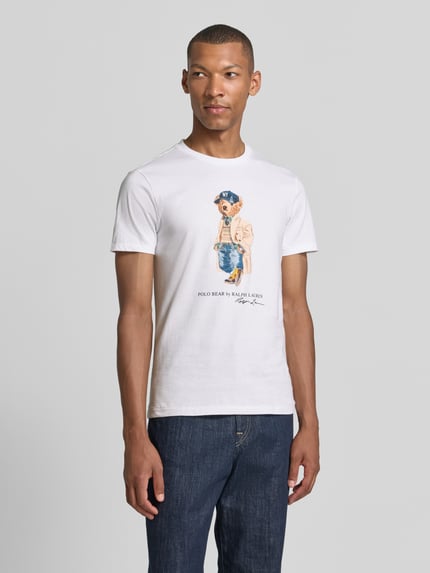 Männermodel trägt weißes slim fit t-shirt aus reine katoen mit polo bear-print Modell '26/1' von Polo Ralph Lauren, heren t-shirt, ganzlichaamsaanzicht van voren.
