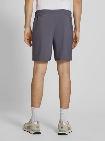 Männermodel trägt Shorts mit Logo und elastischem Bund von PUMA PERFORMANCE in Grau, Regular Fit, elastischer Bund, Ganzkörperansicht Rückansicht.