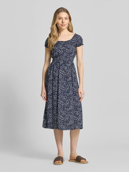 Modelka kobieca nosi Knielanges Kleid aus Viskose im Allover-Look od Apricot w granatowo-białe wzory, krój taliowany, długość do kolan, okrągły dekolt, czysta wiskoza; długość tyłu w rozmiarze S: 106 cm, szerokość w rozmiarze S: 43 cm, długość rękawa w rozmiarze S: 11 cm. Widok całej sylwetki z przodu.