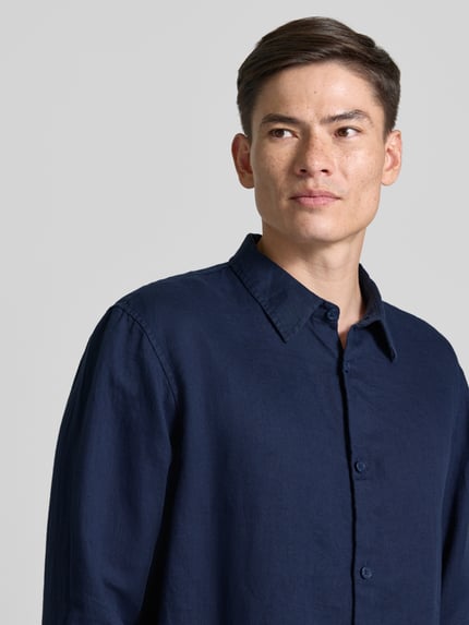 Männermodel trägt Regular Fit Leinenhemd mit Kentkragen von GAP, dunkelblau, reine Leinen, Knopfleiste, Nahaufnahme Oberkörper.