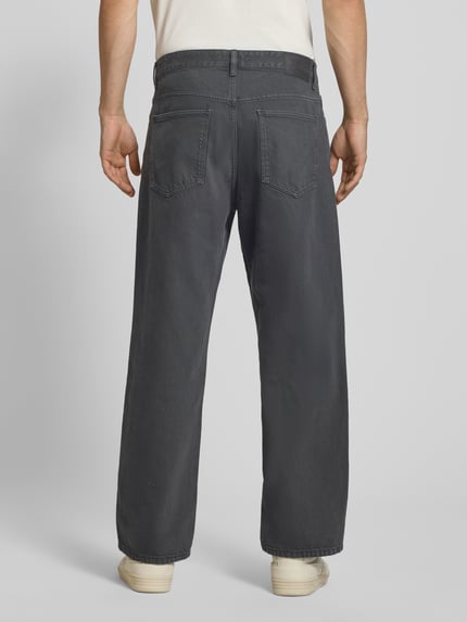 Männermodel trägt Wide Fit Jeans aus reiner Baumwolle Modell 'STEN' von Marc O'Polo Denim in dunklem Grau, Ganzkörperansicht Rückansicht.