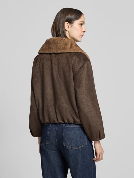 Vrouwenmodel draagt Blouson mit Viskose-Anteil van zero in bruin met kunstbontkraag, materiaal-mix, elastische afwerkingen, achteraanzicht, ruglengte 58 cm, schouderbreedte 48 cm, borstwijdte 58 cm, mouwlengte 52 cm, ontspannen fit. Ganzkörperansicht Rückansicht