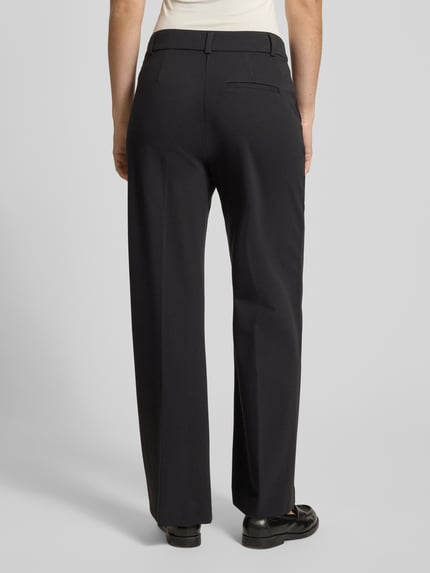 Frauenmodel trägt schwarze Stoffhose mit Gesäßtasche von Comma, Viskose-Mix mit Stretch-Anteil, lockerer Schnitt, Ganzkörperansicht Rückansicht.