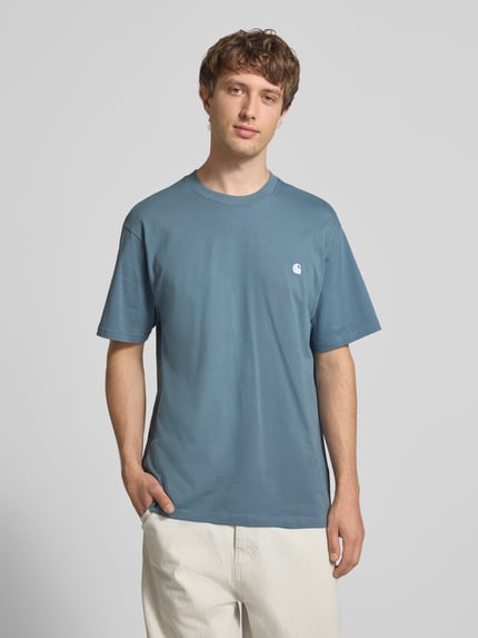 Männermodel trägt Herren T-Shirt mit Label-Stitching Modell 'Madison' von Carhartt Work In Progress aus Reine Baumwolle, Regular-Fit, Rundhalsausschnitt, Rückenlänge bei Größe M 75 cm, Ganzkörperansicht von vorne.