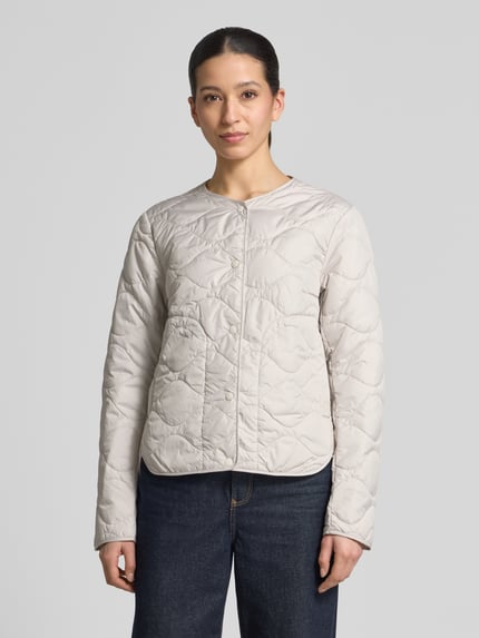 Modelka kobieca ma na sobie kurtka pikowana z okrągłym dekoltem Steppjacke mit Rundhalsausschnitt od camel active, prosty krój, pikowanie, listwa z zatrzaskami, długość tyłu w rozmiarze 36: 60 cm, szerokość ramion w rozmiarze 36: 43 cm, szerokość klatki piersiowej w rozmiarze 36: 53 cm, długość rękawów w rozmiarze 36: 64 cm, jasny kolor, widok całej sylwetki z przodu
