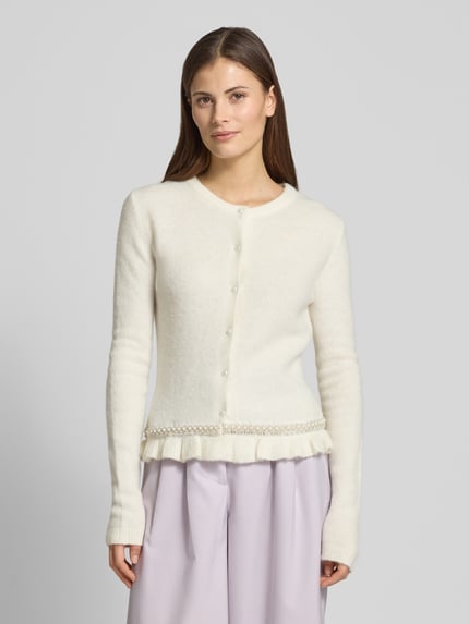 Vrouwenmodel draagt Slim Fit Cardigan in breilook model 'Kate' van GUIDO MARIA KRETSCHMER WOMAN met ruches en siersteentjes, ronde hals, doorlopende knoopsluiting, ruglengte maat 36: 55 cm, wit en lichtpaars, bovenlichaam close-up vooraanzicht.