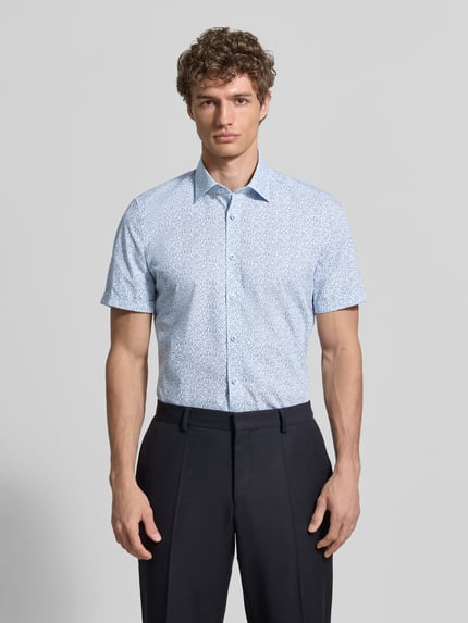 Männermodel trägt Slim Fit Business-Hemd mit Kentkragen von OLYMP Level Five, Baumwoll-Mix mit Stretch-Anteil, feines Muster, Knopfleiste, abgerundeter Saum, Rückenlänge 80 cm, Schulterbreite 40 cm, Ärmellänge 25 cm, Ganzkörperansicht von vorne.
