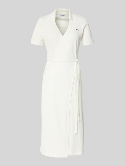 Produktfoto, Slim Fit Wickelkleid aus Baumwoll-Mix von Lacoste, Optik: Unifarben in Weiß, knielang, V-Ausschnitt, Kurzarm, Logo-Stitching, Bindeband, Materialverarbeitung: Piqué