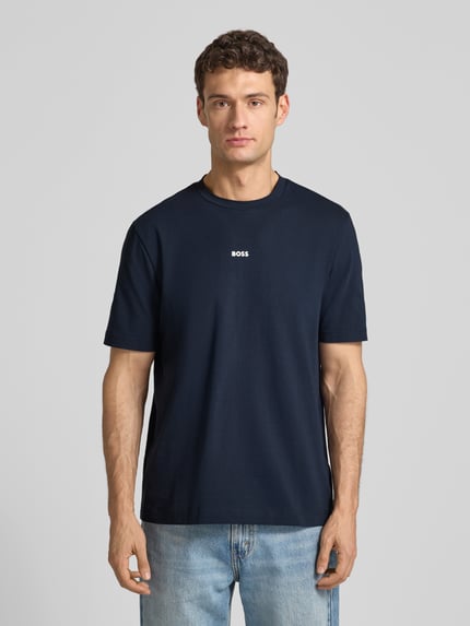 Männermodel trägt T-Shirt mit Label-Print von BOSS, dunkelblau, Baumwoll-Elasthan-Mix, Regular-Fit, Rundhalsausschnitt, Ganzkörperansicht von vorne. Rückenlänge bei Größe M: 70 cm.