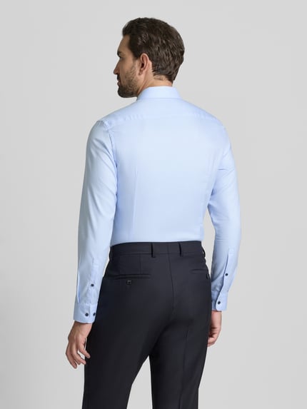 Männermodel trägt Super Slim Fit Business Hemd aus Baumwolle mit Kentkragen von Jake*s, hellblau, glatte Textur, Ganzkörperansicht Rückansicht.