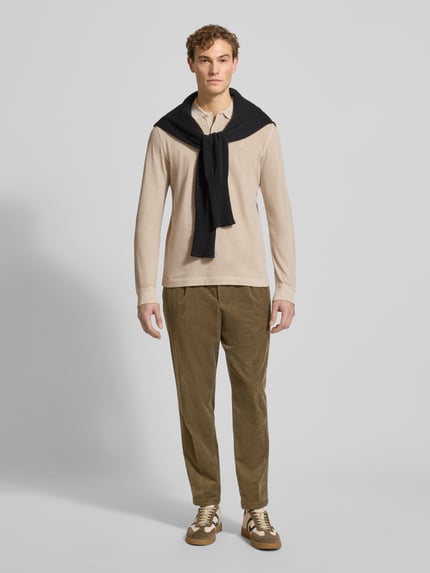 Mannelijk model draagt Regular Fit Poloshirt uit pure katoen van Marc O'Polo, beige, effen, lange mouwen, polokraag, logo detail, volledige lichaamsvoorzijde.