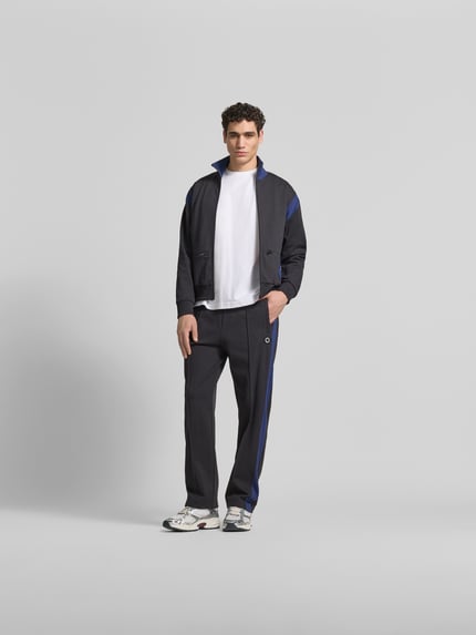 Mannenmodel draagt Sweatpants met Logo-Stitching van Kenzo in puur katoen, straight fit, elastische band, siernaden, heren sweatpants, binnenbeenlengte maat M 43 cm, bandwijdte maat M 79 cm, donker met blauwe details, effen textuur, volledig lichaam vooraanzicht.