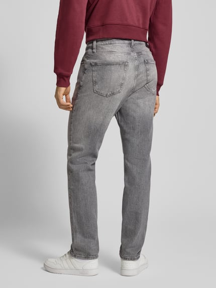Männermodel trägt Straight Fit Jeans aus Baumwoll-Mix von Tommy Jeans in grauer Melange-Optik, 5-Pocket-Design, Ganzkörperansicht Rückansicht.