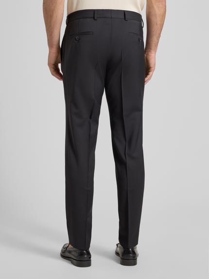 Männermodel trägt Anzughose aus Schurwolle Modell 'Cole' von CG - Club of Gents, Slim Fit, Dunkelgrau, Bügelfalten, Ganzkörperansicht Rückansicht.