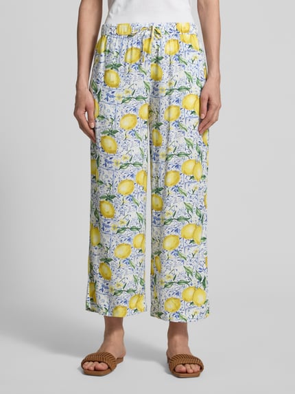 Vrouwenmodel draagt Caprihose aus Viskose im Allover-Look van Christian Berg Woman in wit met gele citroenprint, relaxed fit, elastische tailleband, pure viscose, productdetails volgens context, volledige vooraanzicht.