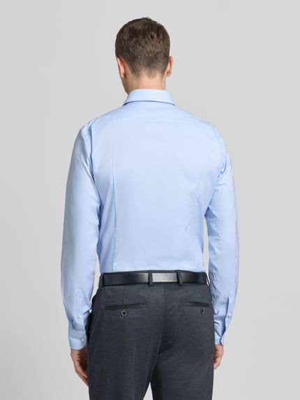 Mannenmodel draagt Regular Fit Businesshemd met extra langem arm van BOSS in effen lichtblauw, katoenmix, afgeronde zoom, rugaanzicht.