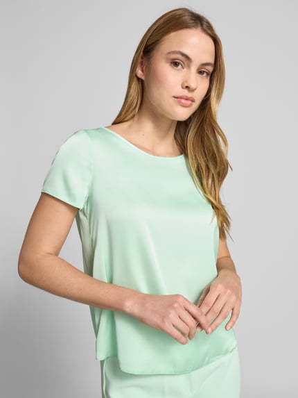 Vrouwenmodel draagt Blusenshirt met Rundhalsausschnitt und abgerundetem Saum van Rinascimento in mintgroen, loose fit, materiaal-mix met stretch, afgeronde zoom, ruglengte maat S 52 cm, Nahaufnahme bovenlichaam