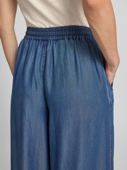 Frauenmodel trägt Wide Leg Weite Hose aus Lyocell Modell 'C_TANELLA' von BOSS Orange im Denim-Look, Detailaufnahme Rückansicht. Damen Weite Hose von BOSS Orange.