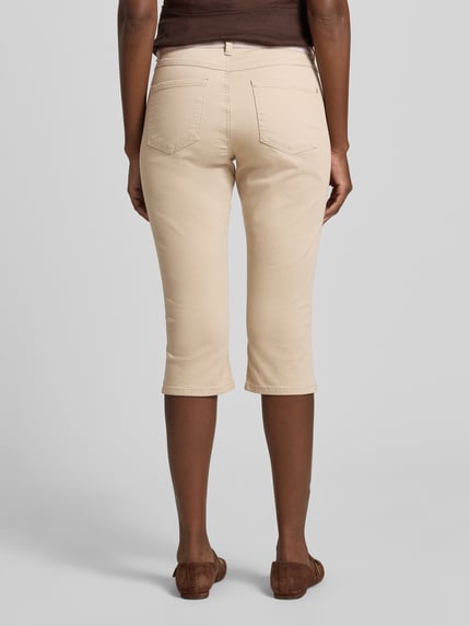 Frauenmodel trägt Caprihose mit elastischem Bund Modell 'AnnaCapri Sporty' von Angels, beige, Baumwoll-Mix mit Stretch-Anteil, Slim-Fit, Ganzkörperansicht Rückansicht