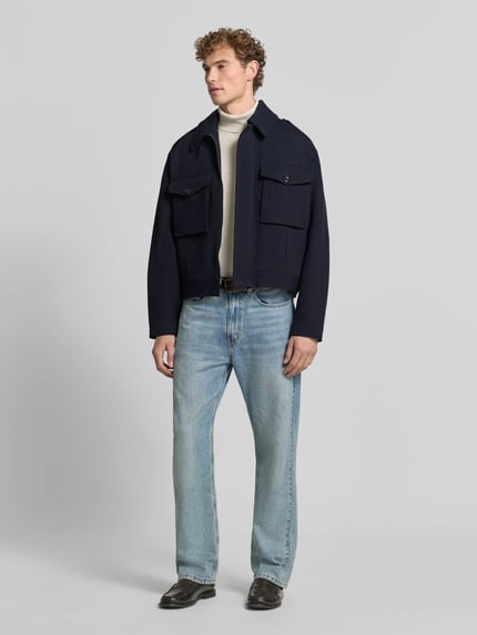 Männermodel trägt Jacke aus Viskose-Mix von Emporio Armani in Dunkelblau, gerade Passform, Umlegekragen, Ganzkörperansicht von vorne. Rückenlänge 64 cm, Schulterbreite 54 cm, Brustweite 64 cm, Ärmellänge 66 cm.