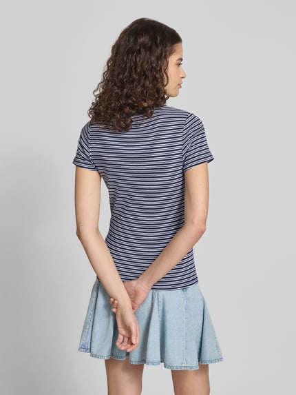 Frauenmodel trägt Slim Fit T-Shirt aus reiner Baumwolle von Levi's®, gestreift, Allover-Muster, Label Patch, Ganzkörperansicht Rückansicht.