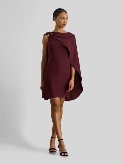 Frauenmodel trägt Tailliertes Cocktailkleid mit Umhang von Lauren Ralph Lauren in Bordeaux, unifarben, Mini, ohne Ärmel, mit U-Boot-Ausschnitt, metallische Akzente, enganliegend, Nahtreißverschluss, Ganzkörperansicht von vorne