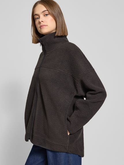 Vrouwenmodel draagt Fleecejacke mit Stehkragen Modell 'COZY' van Noisy May in zwart met rits, ruwe textuur, relaxed fit, Ganzkörperansicht van voren.