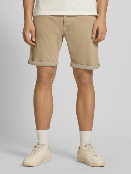 Männermodel trägt Regular Fit Shorts mit Umschlag Modell 'RICK' von Jack & Jones, beigefarbener Baumwoll-Mix, Nahaufnahme Oberschenkel, Vorderansicht.